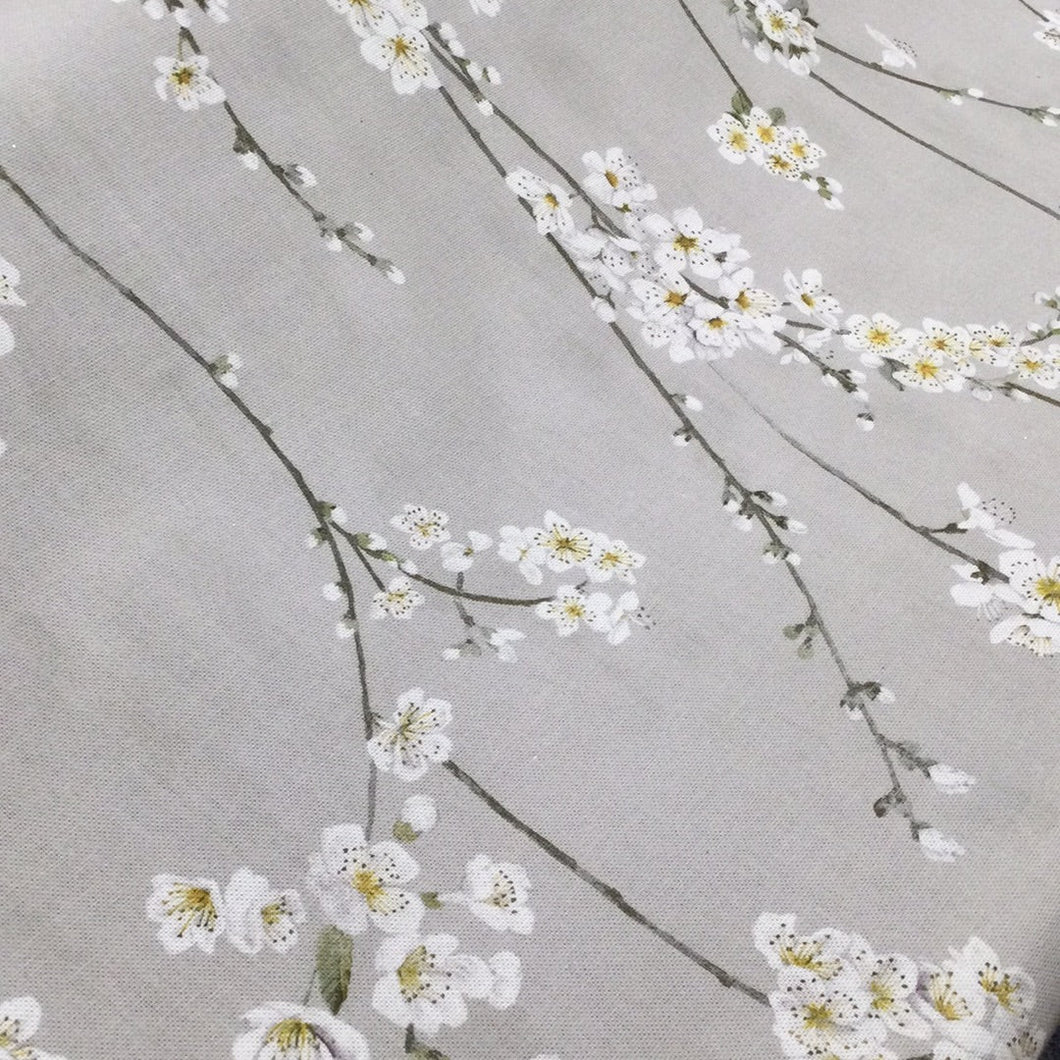 cotton printed fabric with white blossom flowers on a grey base background
